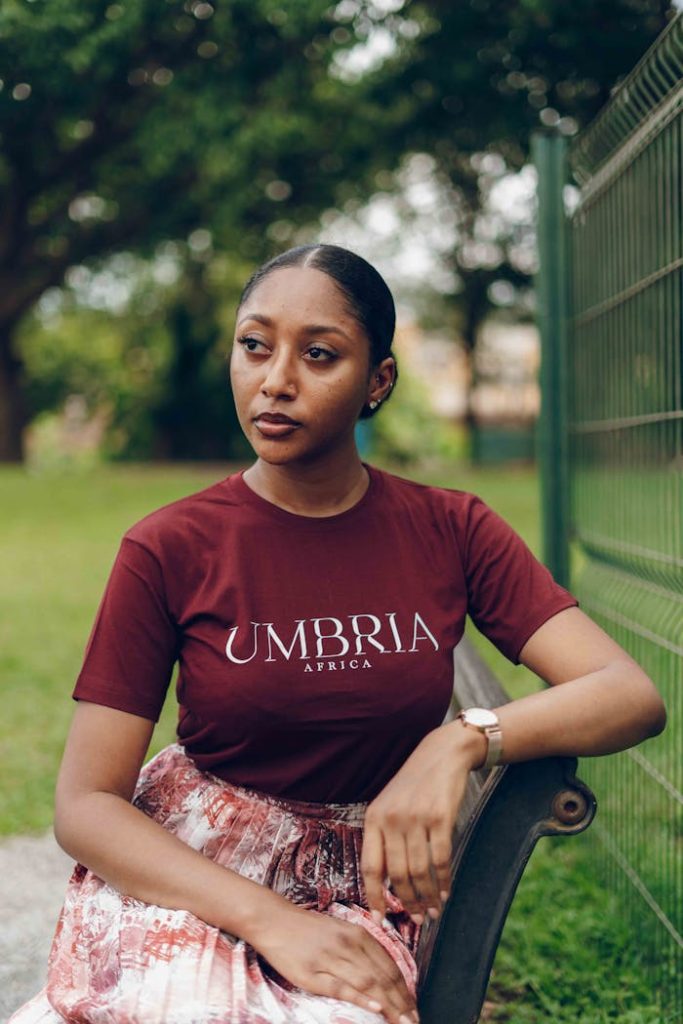 A stylish Nigerian woman poses outdoors, showcasing modern African fashion.